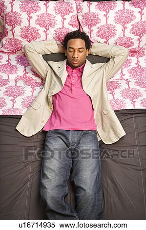 Stock Photography - Male sleeping on bed. Fotosearch