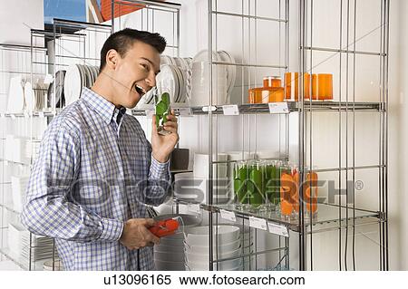 Stock Photography - Man shopping for dishes in a store. Fotosearch