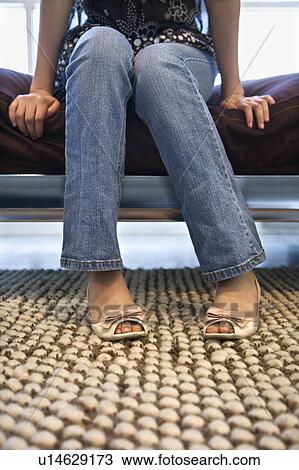 Stock Image - Woman sitting on bed. Fotosearch
