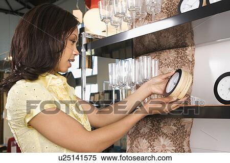 Young woman shopping for clocks in retail shopping setting View Large Photo Image Stock Photography - Young woman shopping for clocks in retail shopping setting. Fotosearch