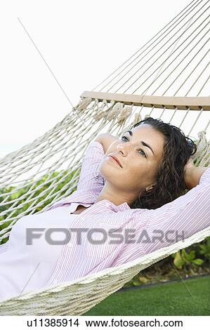 Picture - Female lying in hammock relaxing. Fotosearch