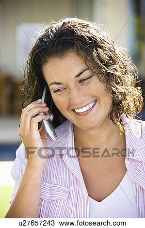 Stock Image - Smiling woman on a cell phone. Fotosearch