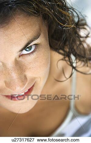 Stock Photo - Woman looking up at viewer smiling. Fotosearch