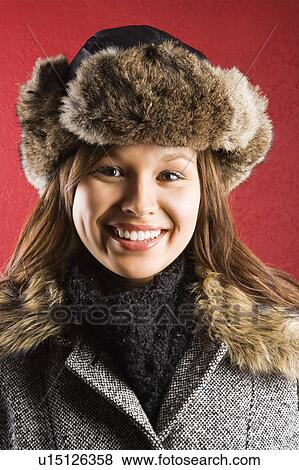 Stock Photo - Young adult Caucasian woman wearing fur hat smiling at viewer.. Fotosearch