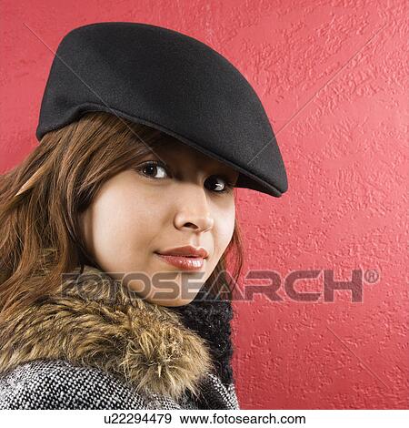 Stock Photo - Young adult Caucasian woman wearing flat hat looking at viewer.. Fotosearch