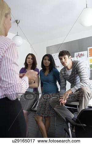 Stock Photo - Businesswoman giving team talk. Fotosearch
