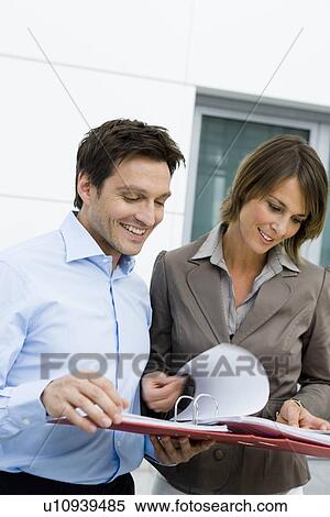 Man and woman reading a file View Large Photo Image Stock Photography - Man and woman reading a file. Fotosearch