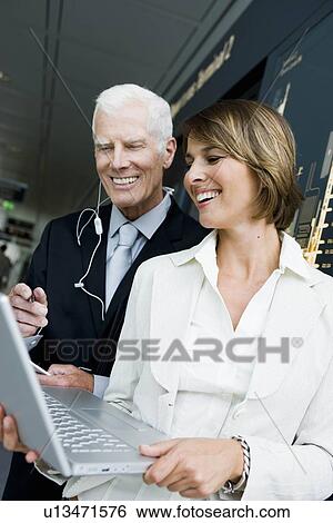 Stock Photograph - Older man and woman looking at laptop. Fotosearch