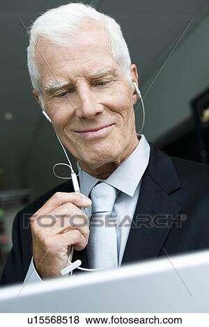 Older man listening wearing head phones View Large Photo Image Stock Photo - Older man listening wearing head phones. Fotosearch
