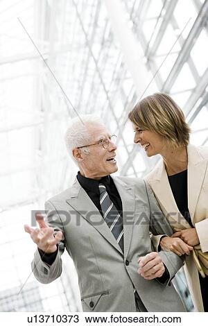 Older man talking to younger woman View Large Photo Image Stock Image - Older man talking to younger woman. Fotosearch
