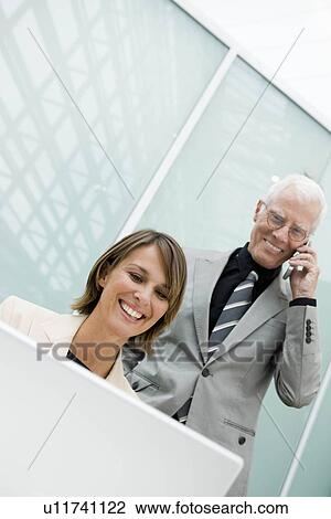 Stock Image - Woman and older man in working situation. Fotosearch