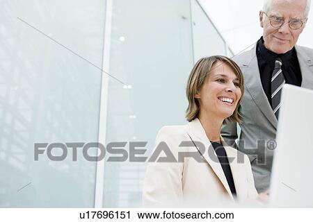 Stock Image - Woman and older man in working situation. Fotosearch