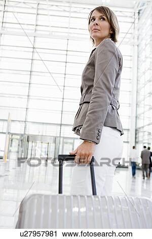 Woman at airport dragging suitcase View Large Photo Image Stock Image - Woman at airport dragging suitcase. Fotosearch