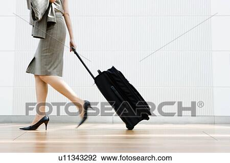 Woman dragging a suitcase View Large Photo Image Stock Image - Woman dragging a suitcase. Fotosearch
