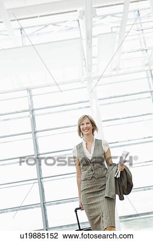 Stock Image - Woman dragging a suitcase. Fotosearch