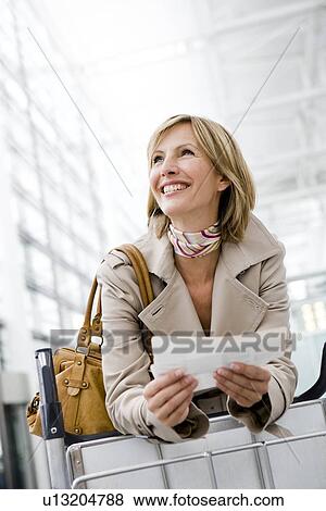 Woman holding ticket smiling View Large Photo Image Stock Photo - Woman holding ticket smiling. Fotosearch