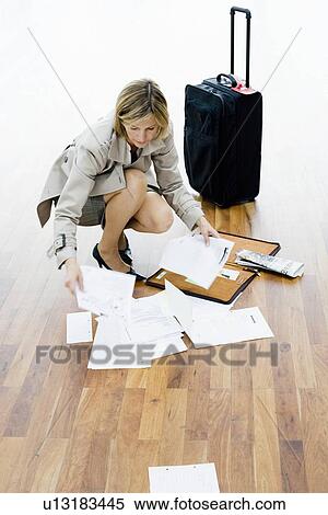 Woman sorting papers spread on floor View Large Photo Image Stock Photography - Woman sorting papers spread on floor. Fotosearch