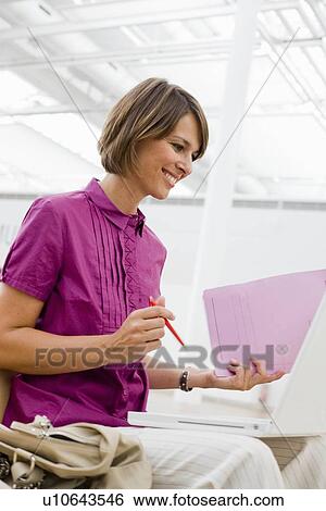Woman with pen and paper smiling View Large Photo Image Stock Photograph - Woman with pen and paper smiling. Fotosearch