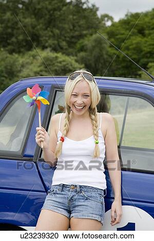 Young woman and windmill by electric car View Large Photo Image Stock Image - Young woman and windmill by electric car. Fotosearch