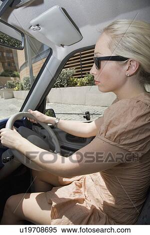 Stock Photography - Young woman driving electric car. Fotosearch