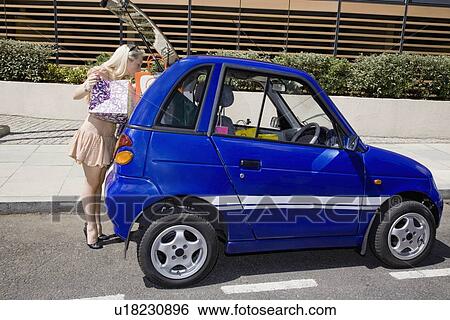 Young woman loading electric car View Large Photo Image Stock Photograph - Young woman loading electric car. Fotosearch