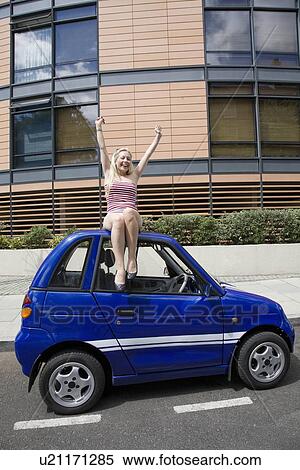 Young woman waving on electric car View Large Photo Image Stock Photography - Young woman waving on electric car. Fotosearch