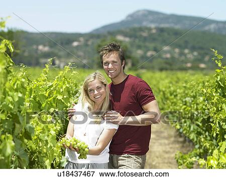 Stock Photo - Couple in vineyard with grapes. Fotosearch