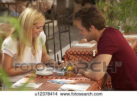 Couple writing postcards in cafe View Large Photo Image Picture - Couple writing postcards in cafe. Fotosearch