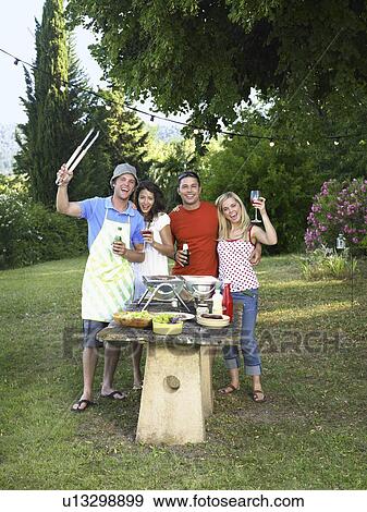 Stock Photo - Friends celebrating at barbecue. Fotosearch