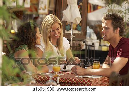 Stock Photograph - Friends in french market cafe. Fotosearch