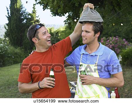Two men laughing at barbecue View Large Photo Image Stock Photo - Two men laughing at barbecue. Fotosearch