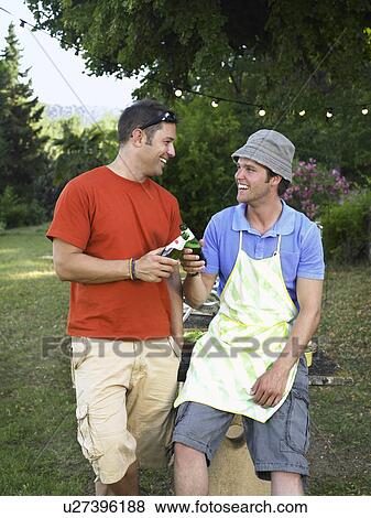 Stock Photo - Two men toasting at barbecue. Fotosearch