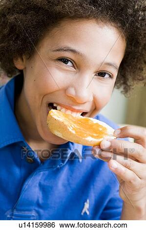 Stock Photograph - Boy eating a jam bread. Fotosearch