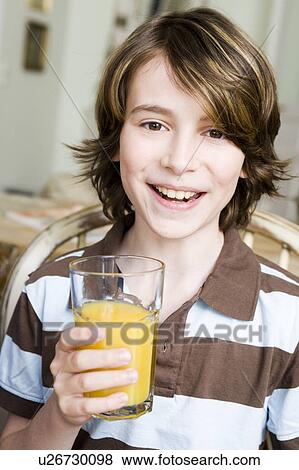 Boy smiling with a glass of orange juice View Large Photo Image Stock Photo - Boy smiling with a glass of orange juice. Fotosearch