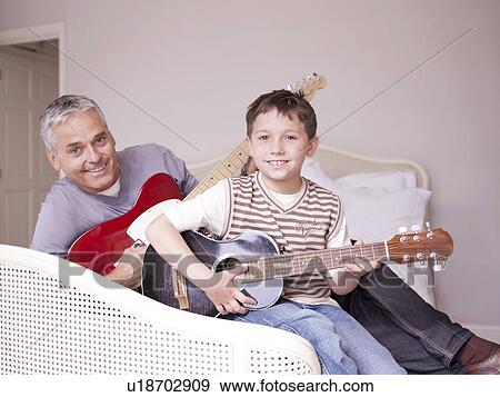 Father and son on bed with guitar View Large Photo Image Stock Photo - Father and son on bed with guitar. Fotosearch