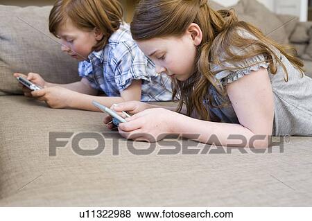 Stock Photo - Girl and boy playing video games. Fotosearch