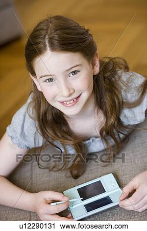 Girl playing video games, looking up View Large Photo Image Stock Image - Girl playing video games, looking up. Fotosearch