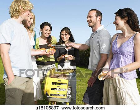 Stock Photo - Group of people around barbecue. Fotosearch