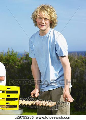 Man with sausages next to barbecue View Large Photo Image Stock Photography - Man with sausages next to barbecue. Fotosearch