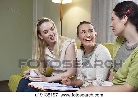 Three young women sitting on couch View Large Photo Image Stock Photo - Three young women sitting on couch. Fotosearch