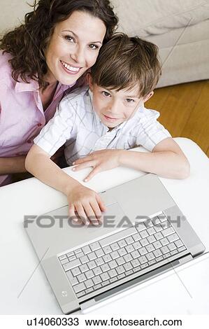 Woman and son looking up with laptop View Large Photo Image Stock Image - Woman and son looking up with laptop. Fotosearch