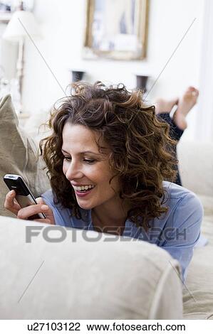 Woman texting on her handy, laying View Large Photo Image Stock Image - Woman texting on her handy, laying. Fotosearch