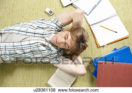 Stock Photo - Young man lying on rug. Fotosearch