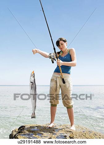 Young woman holding fish View Large Photo Image Stock Photo - Young woman holding fish. Fotosearch