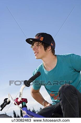 Teen boy sitting on bike View Large Photo Image Stock Image - Teen boy sitting on bike. Fotosearch
