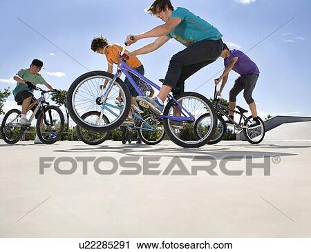 Teen boys riding bikes View Large Photo Image Stock Image - Teen boys riding bikes. Fotosearch