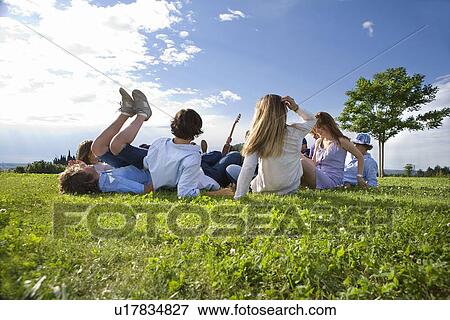 Teen group laying on grass in park View Large Photo Image Stock Photo - Teen group laying on grass in park. Fotosearch