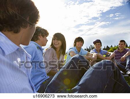 Teen group sitting on grass, talking View Large Photo Image Stock Image - Teen group sitting on grass, talking. Fotosearch
