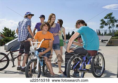 Stock Photo - Teen group with bikes talking. Fotosearch