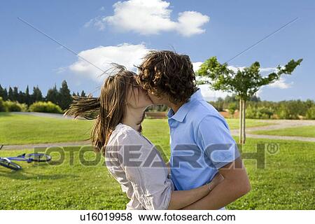 Teen lovers kissing in park View Large Photo Image Stock Photo - Teen lovers kissing in park. Fotosearch